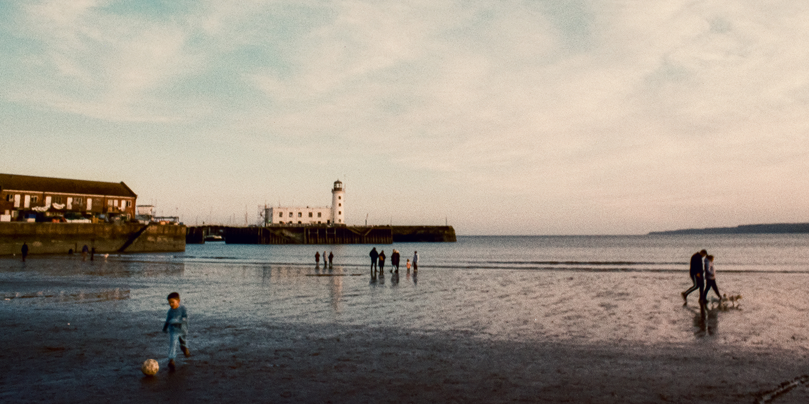 Scarborough seafront with young child playing football
